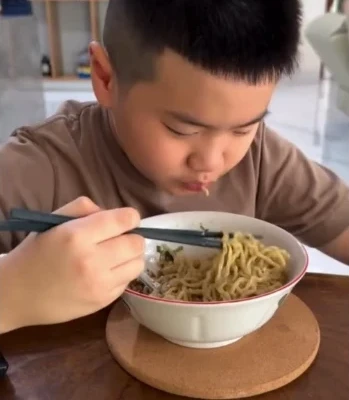 Seorang anak menikmati semangkok mie ayam